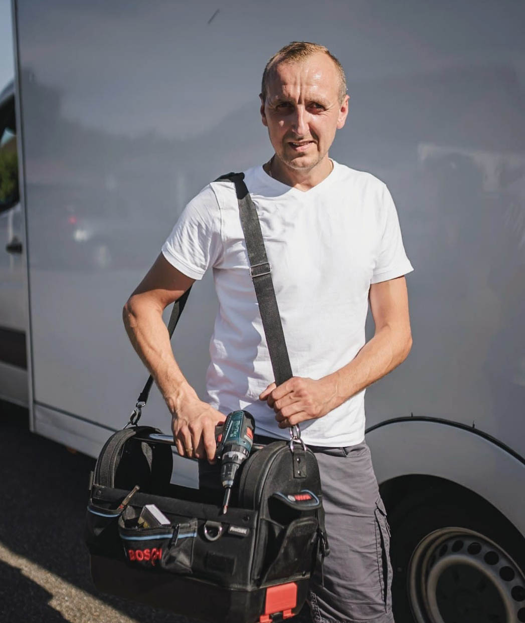 Mitarbeiter eines Umzugsunternehmens Ulm mit Werkzeugtasche vor Umzugsfahrzeug